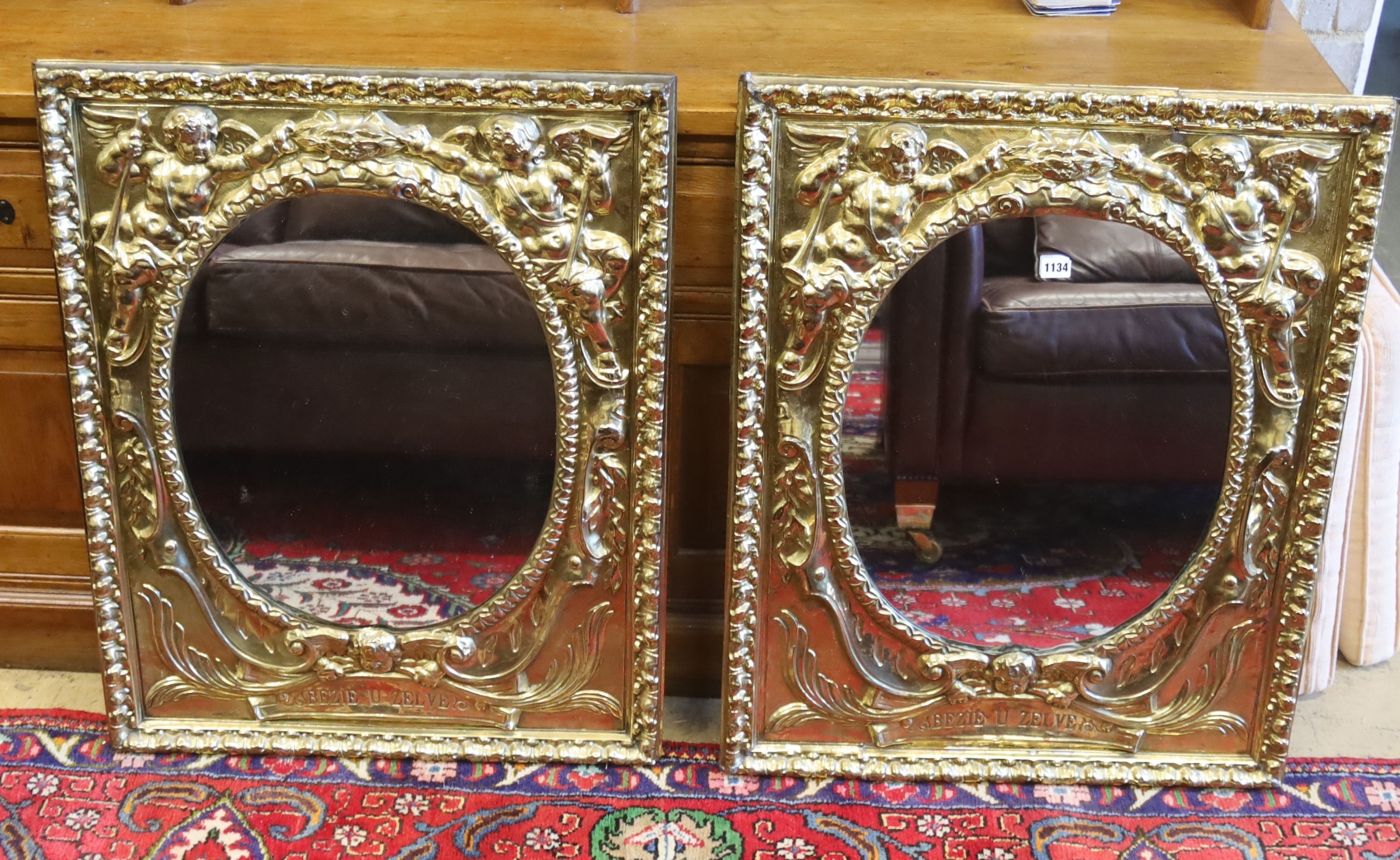 A pair of late 19th/early 20th century Dutch embossed brass framed mirrors with oval plates, width 66cm, height 84cm